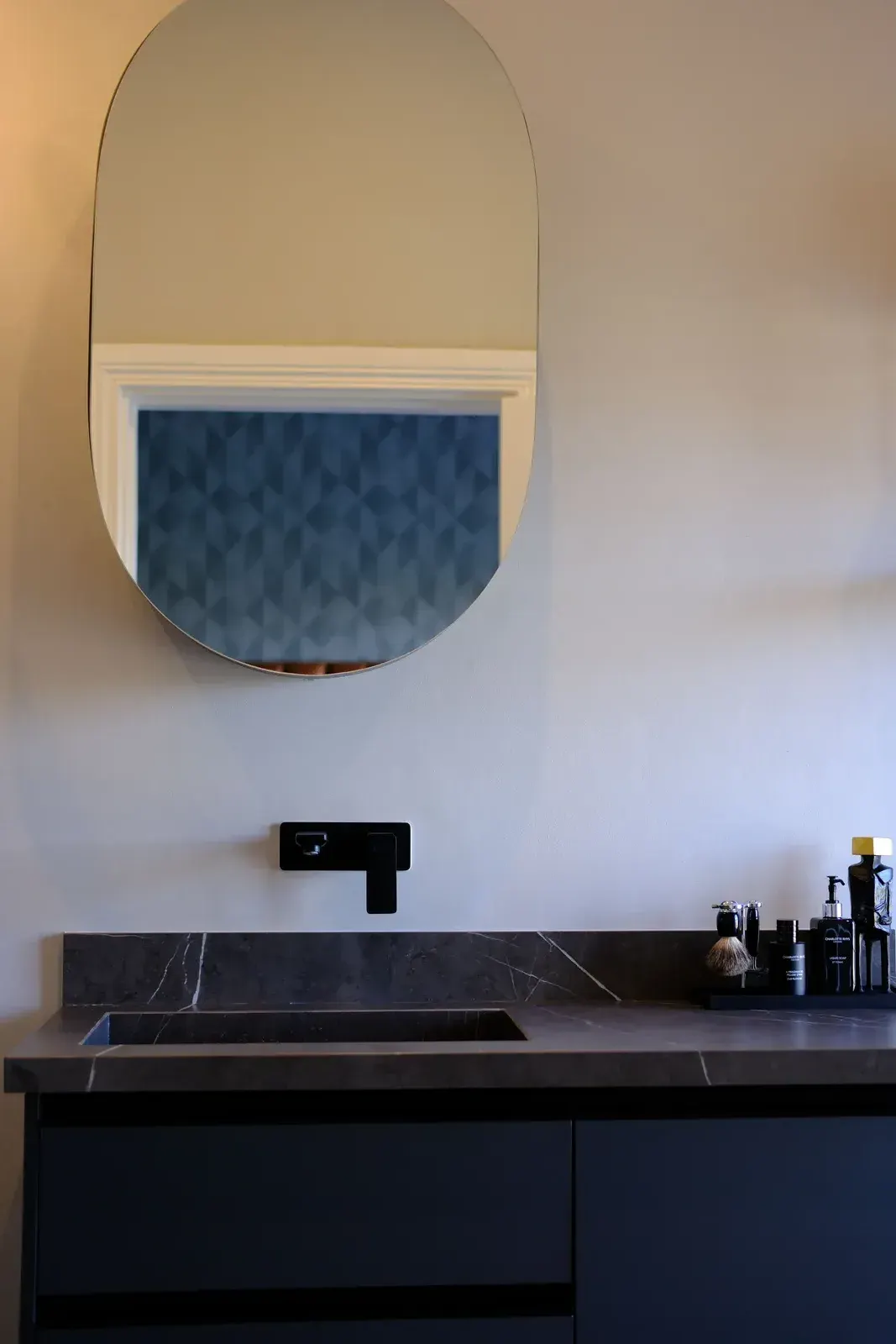 Matte black wall-mounted basin mixer on a dark stone vanity