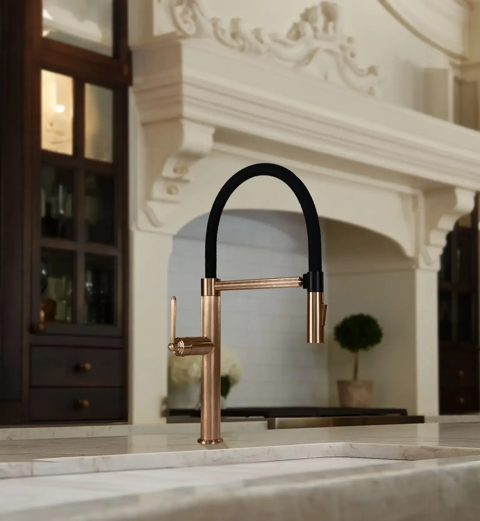 Rose gold kitchen mixer with a black flexible spout over a stone benchtop