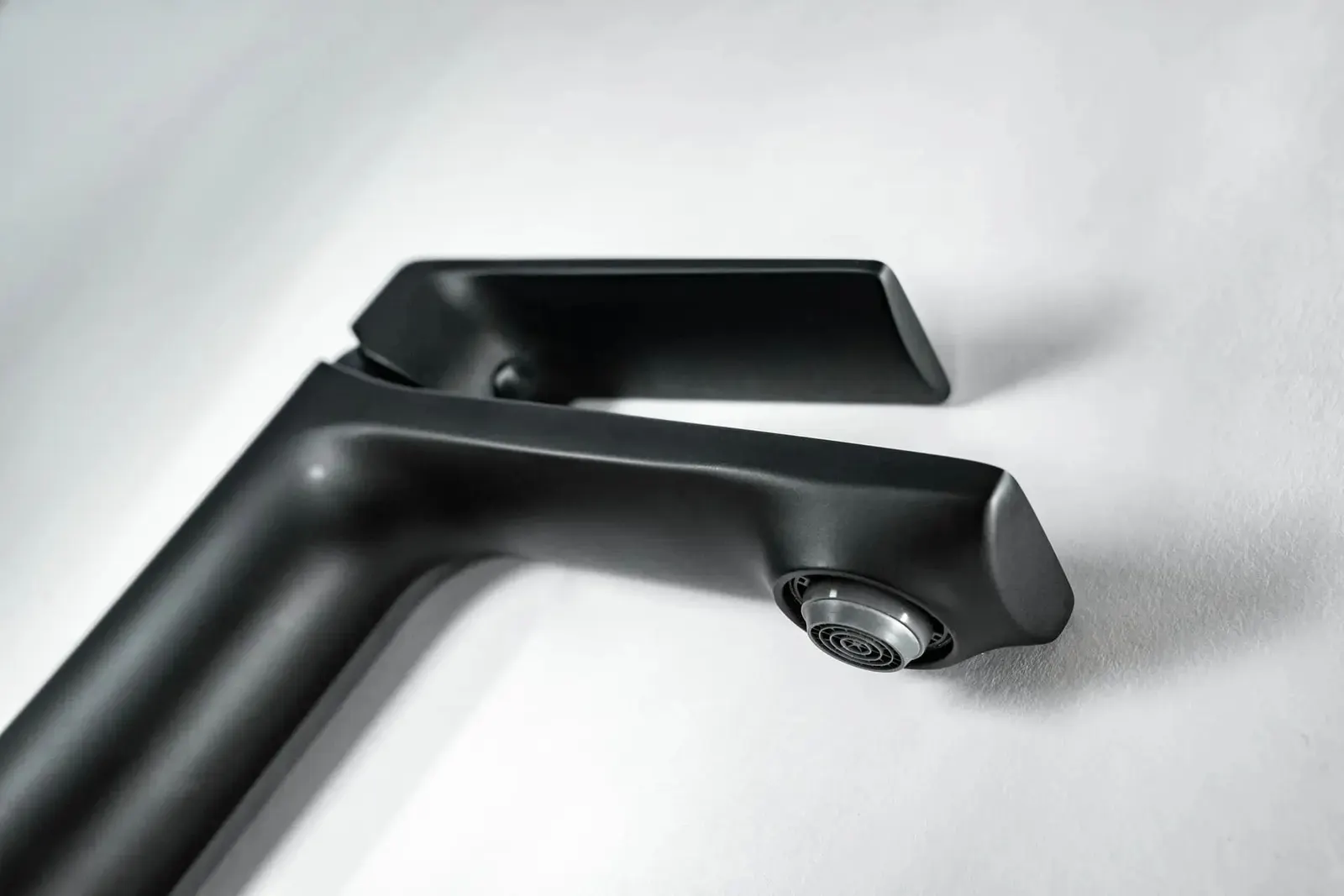 Matte black tall basin mixer on a white basin