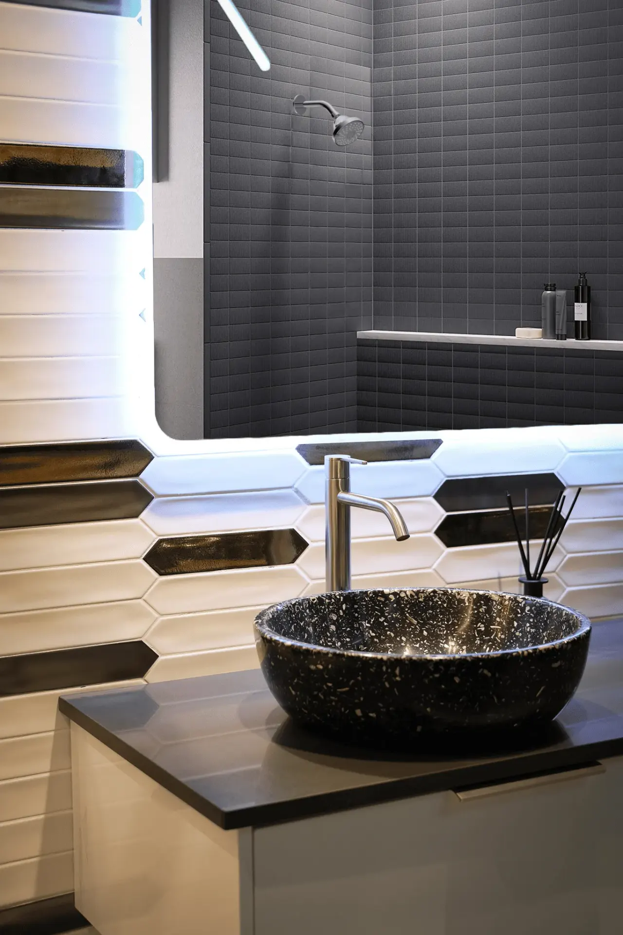 Brushed brass basin mixer on a speckled stone vessel basin